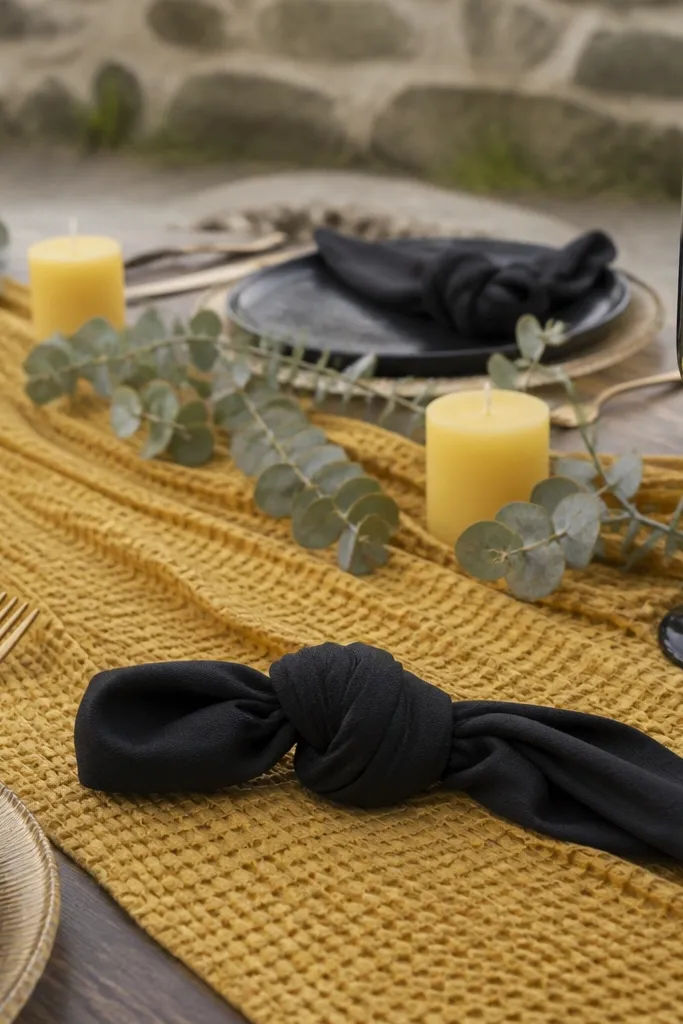 Honeycomb yellow runner on sweetheart table with black napkin rings