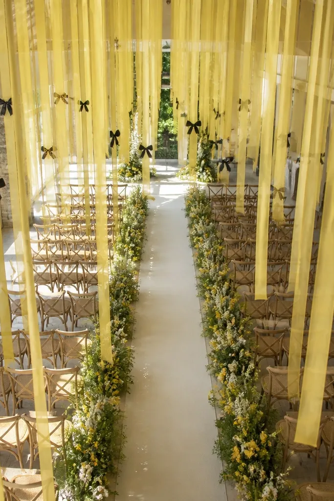 Yellow ribbon ceiling drops over the ceremony aisle with black accents