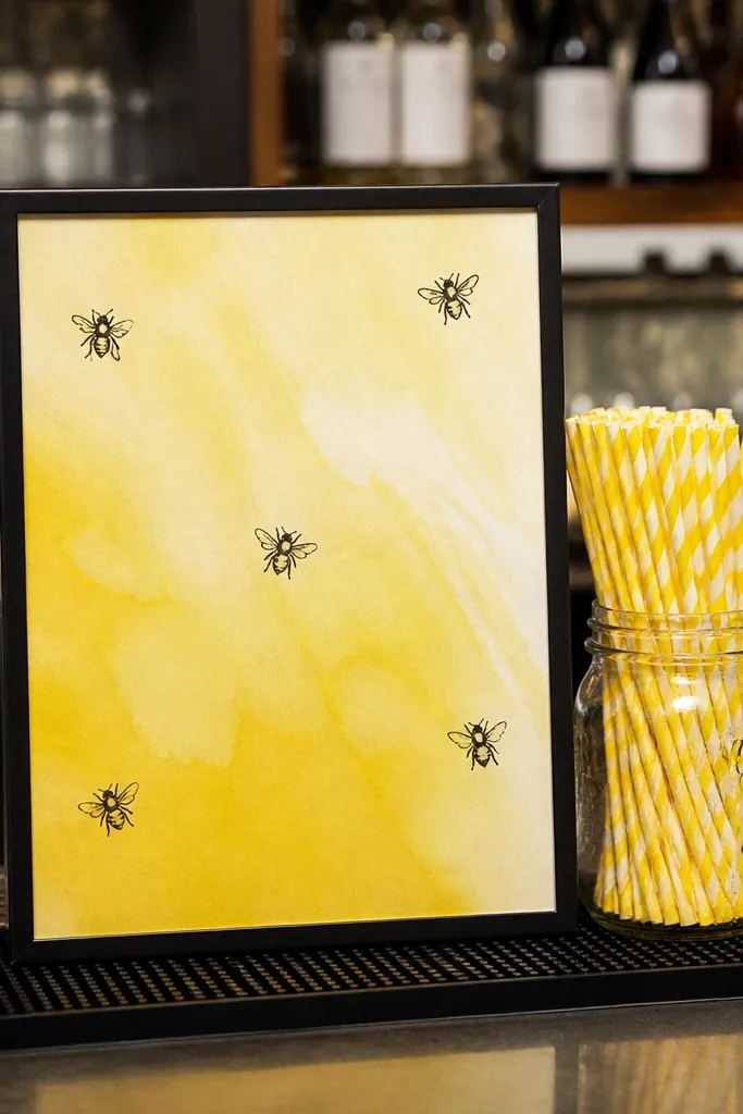 Bar sign with lemon-yellow background and bee-themed icons