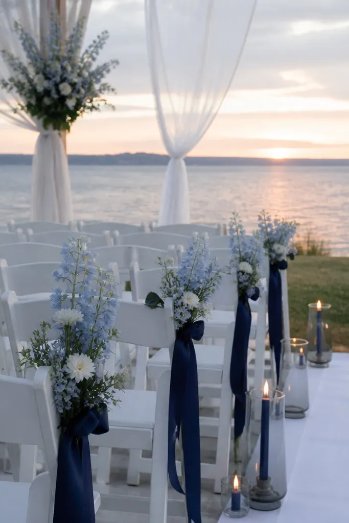 White linens with navy napkins, soft blue florals, and navy ribbon on menus