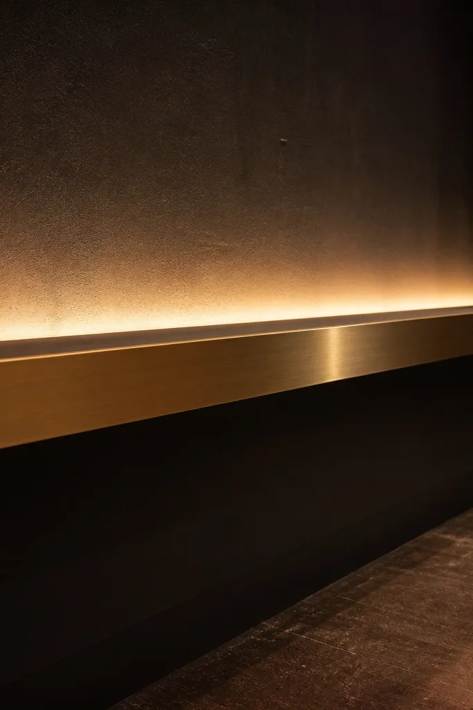Gold-trim lighting shelf with warm LED uplight behind stage