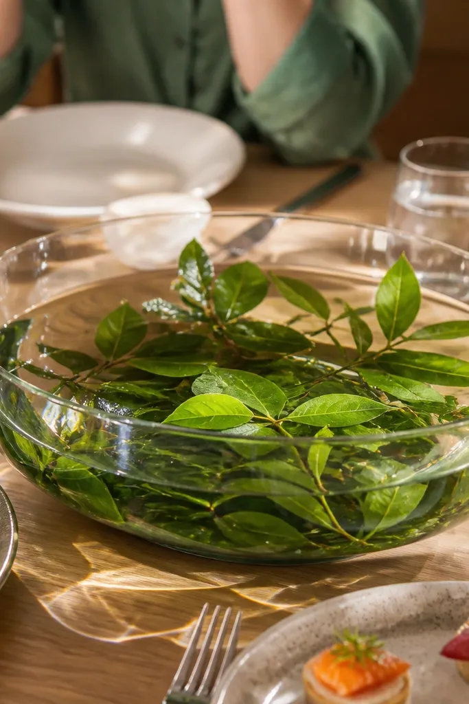 Bowl centerpiece with layered leaves and floating stems