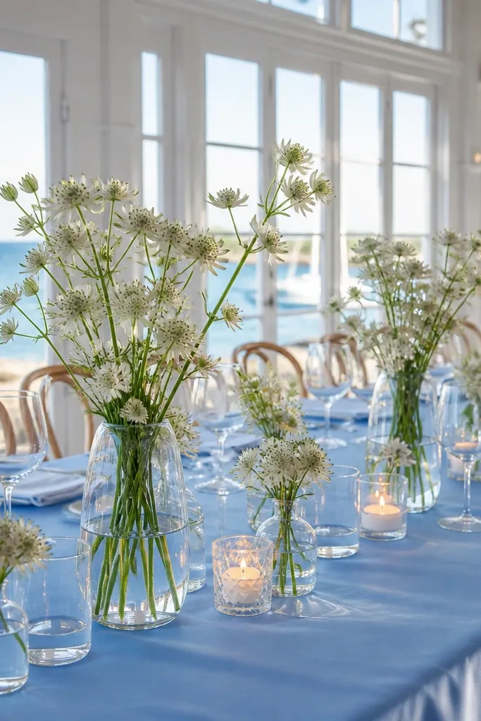 Porcelain blue tablecloth with white astrantia in clear vases and soft candles
