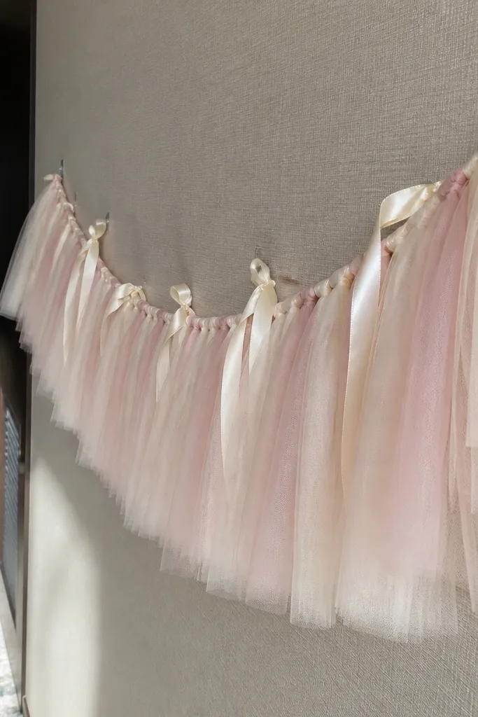 Light blush tulle garland with cream ribbon draped along a hallway wall