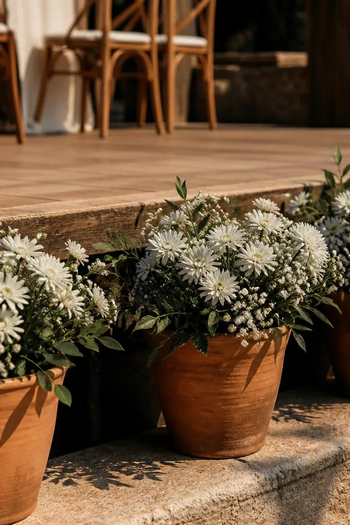Terracotta pots with white flowers lining the stage edge