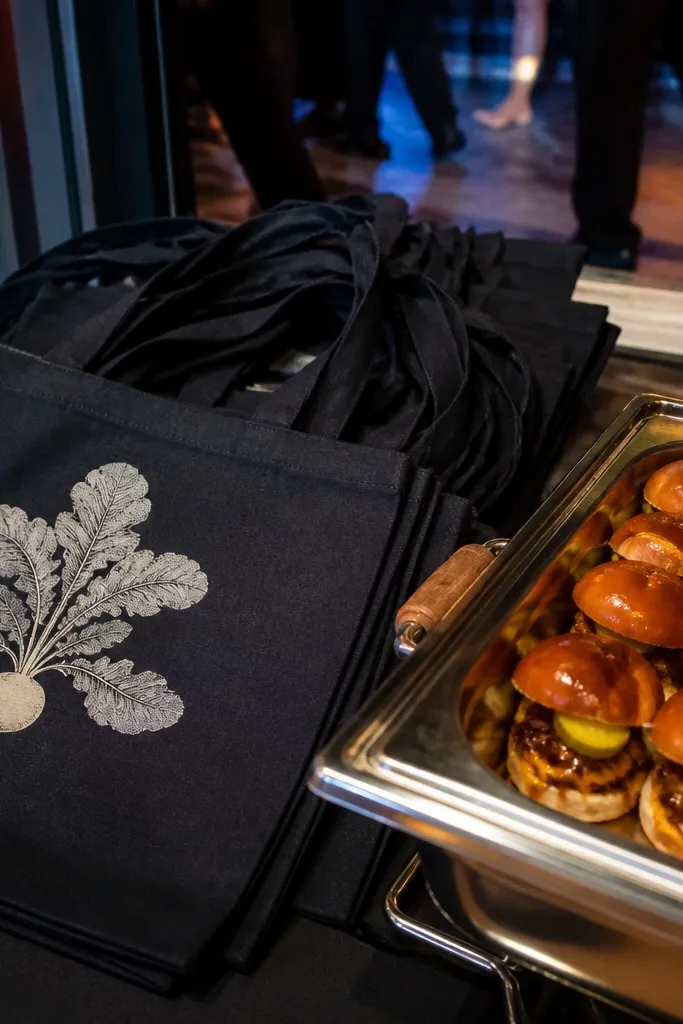 Brown kraft totes with mini burger sliders and a handwritten menu card.