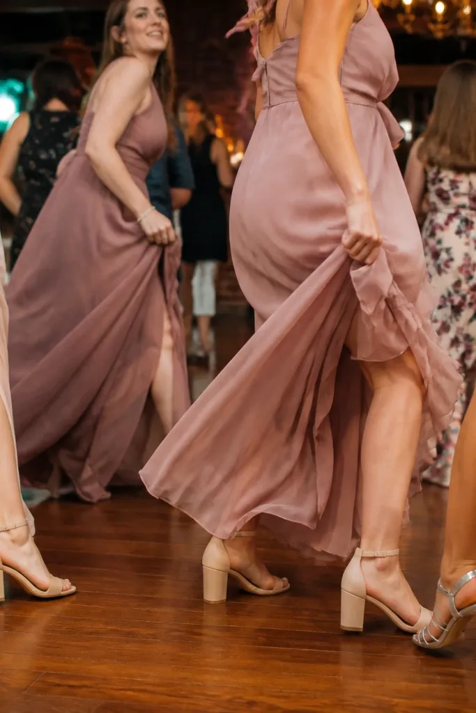 Bridesmaids dancing with visible shoes and dress hems on a dance floor