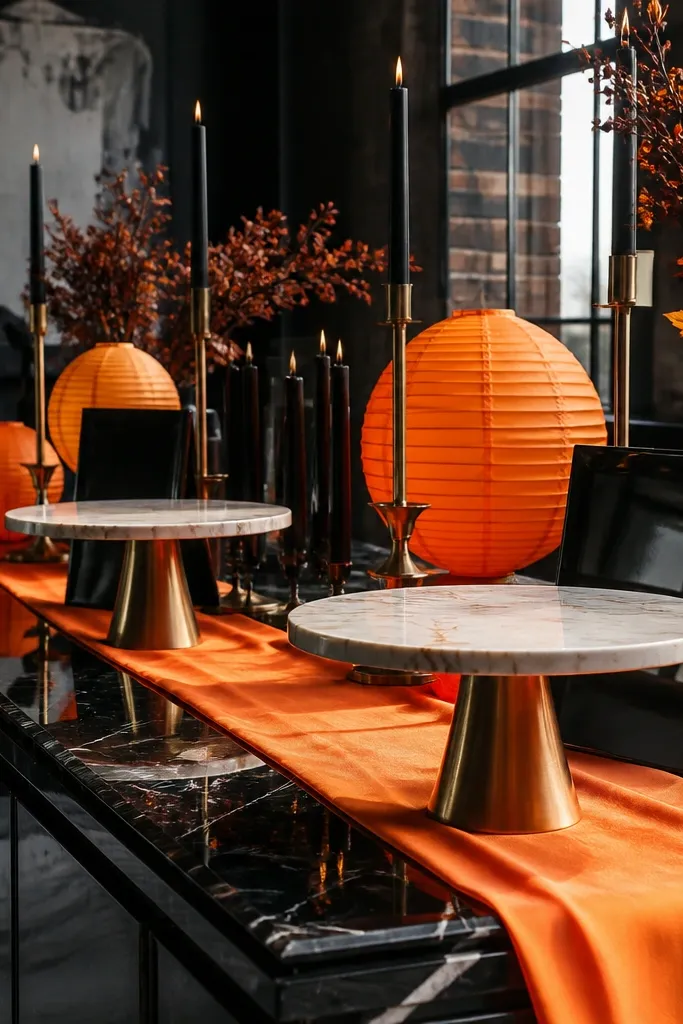 Bright orange table decor with black accents and ivory marble-style place cards