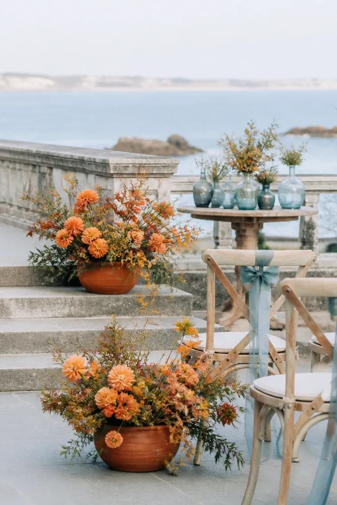 Sea glass blue accents with persimmon flowers and warm gray table decor