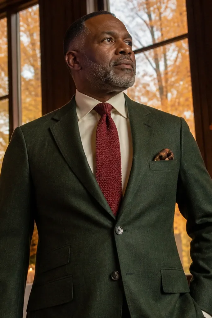 Deep green wool suit with ivory shirt and burgundy grenadine tie, plus dark leather shoes