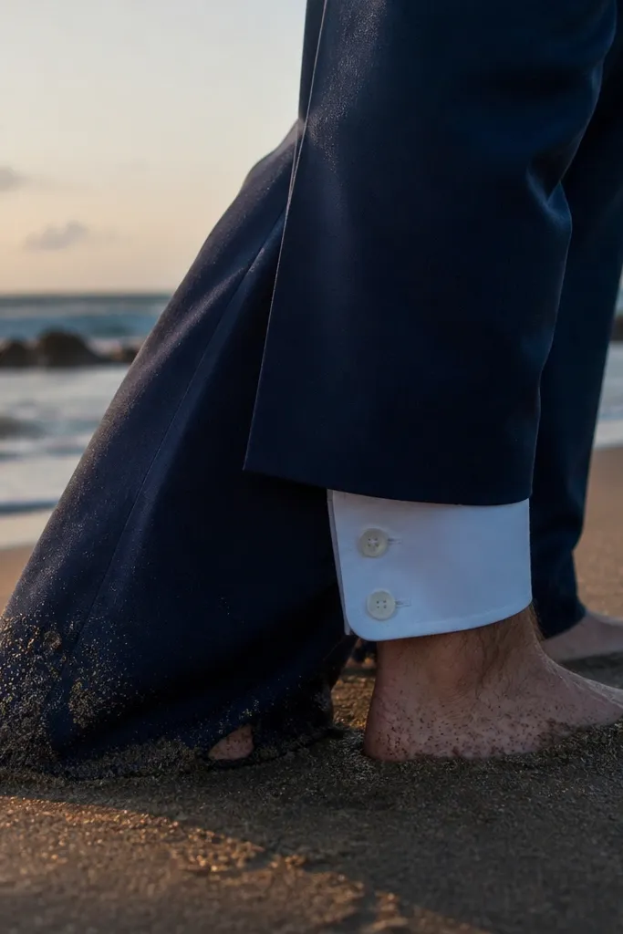 Groom's suit cuff and shoes with sand texture in frame