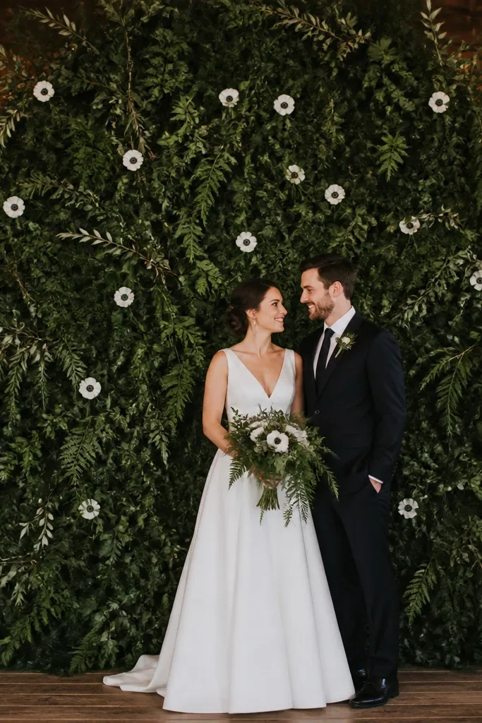 Monochrome green foliage with scattered white anemone blooms on a wedding stage