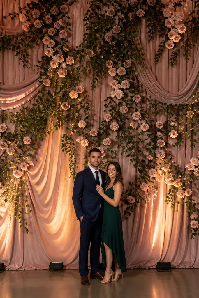 Rose and ivy draped curtain with warm amber lights behind the stage