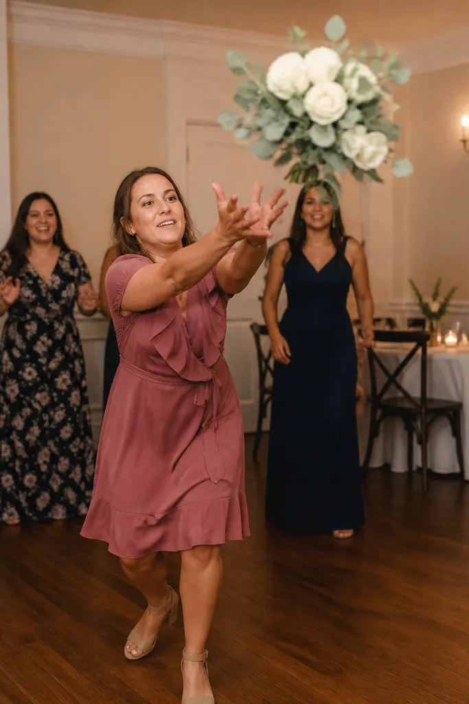 Bouquet mid-air with a plain wall behind and guests reaching in