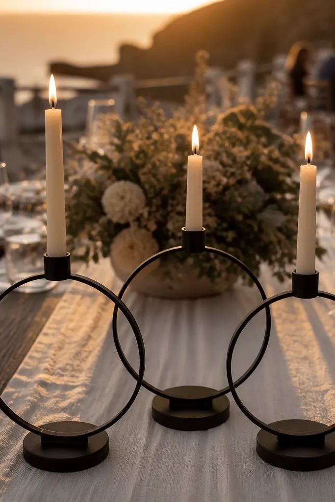 Matte black candle ring holders with white tapers on a dark table runner