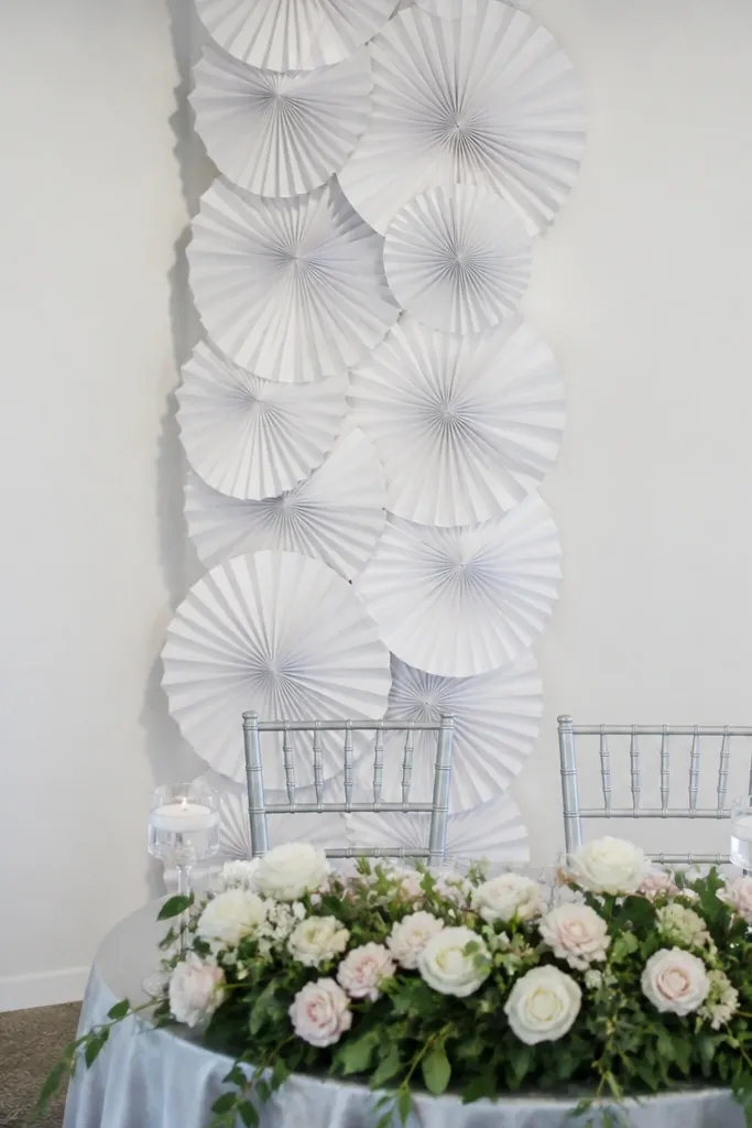 White folded paper fan strips arranged as a vertical backdrop