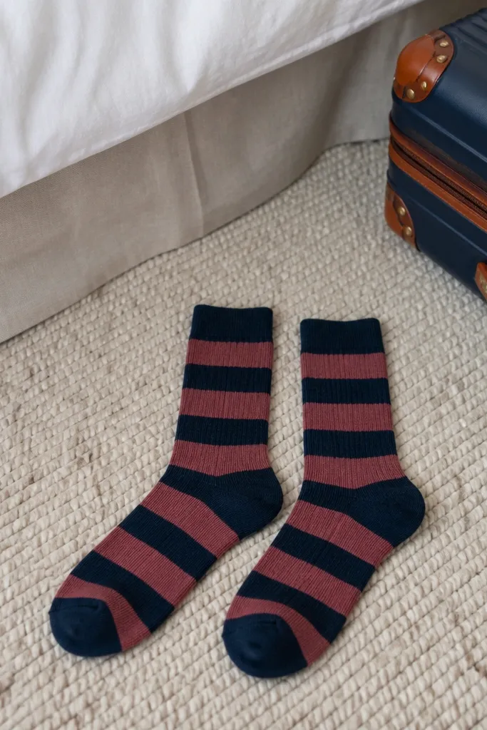 Pair of socks in dusty rose and cream folded inside a small gift box