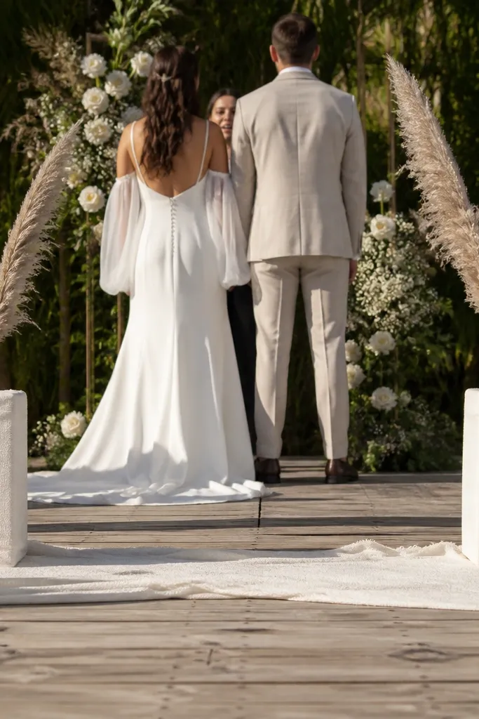 Two rectangular foam blocks wrapped in cream fabric at stage edges with pampas