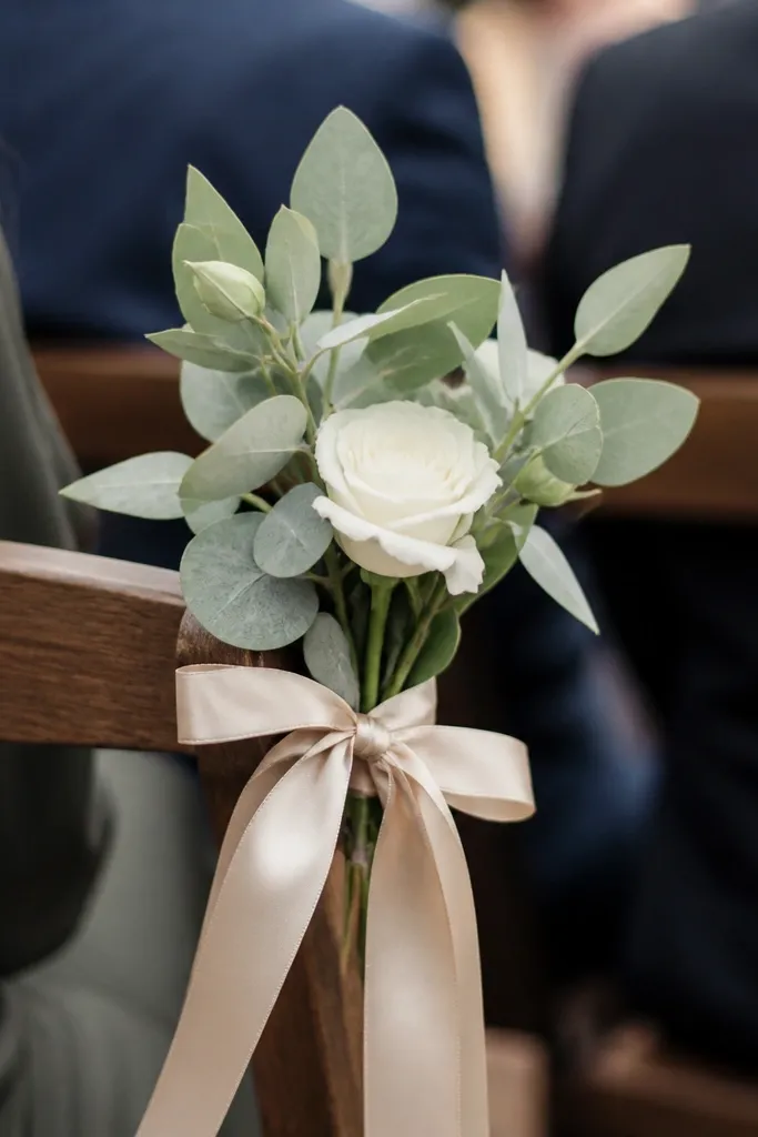 Small bud bouquet tied to the side of a ceremony chair with a ribbon
