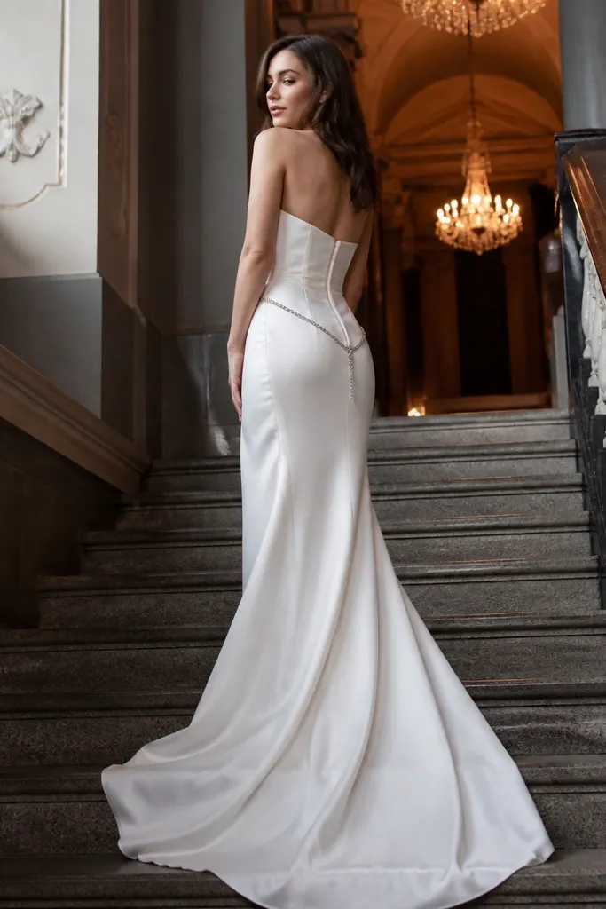 White silk corset wedding dress with a delicate silver chain at the waist and chandelier earrings