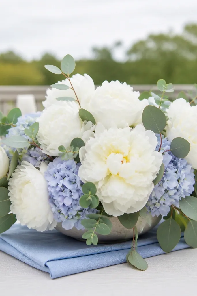 Powder blue napkins with sage greenery and white peonies