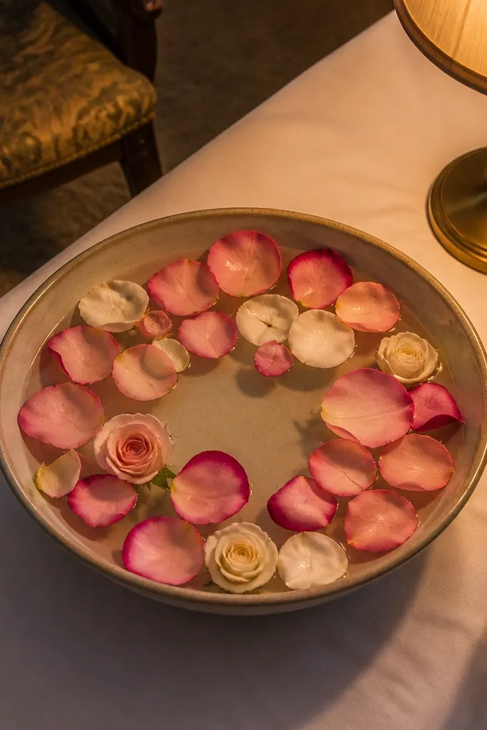 Low glass bowl centerpiece with floating petals and small rose heads