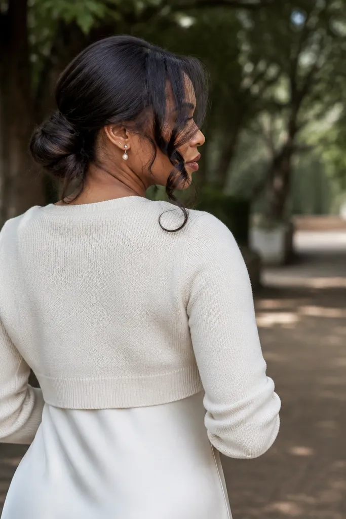 Low bun with a looping strand wrapped around the base like a waterfall