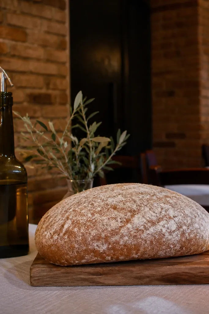 Brick-walled pizzeria with rustic bread on the table and simple candle decor