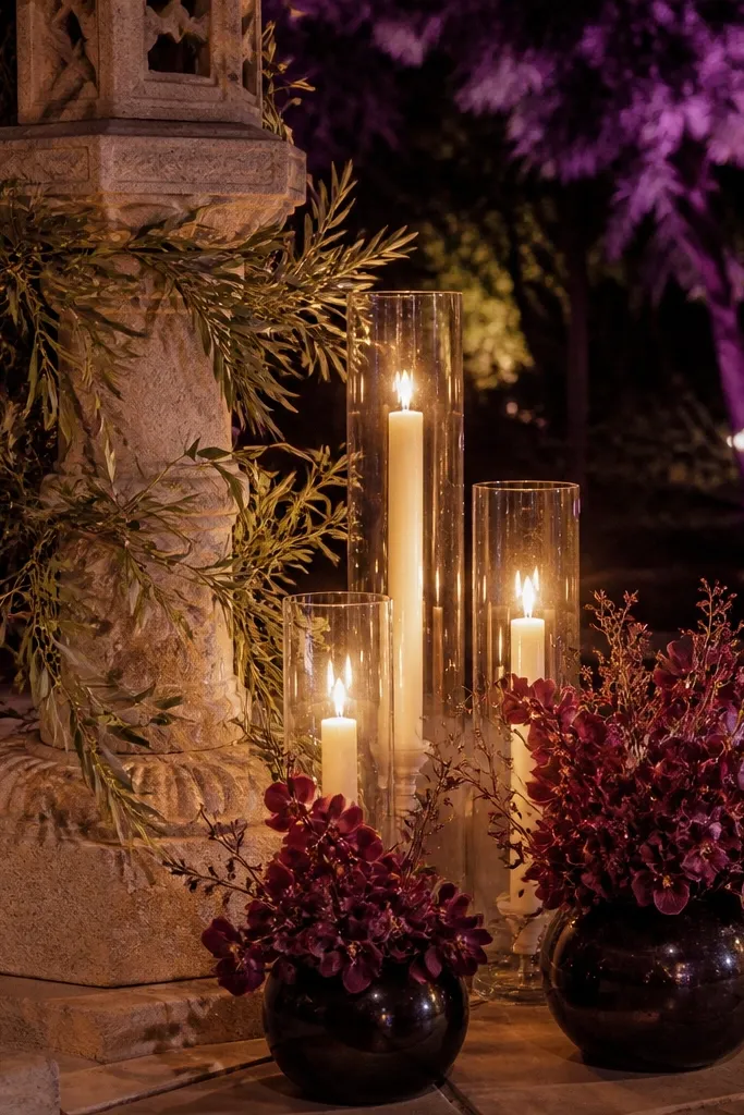 Ivory tablecloth, olive foliage bouquet, deep plum accents, and brass candlesticks