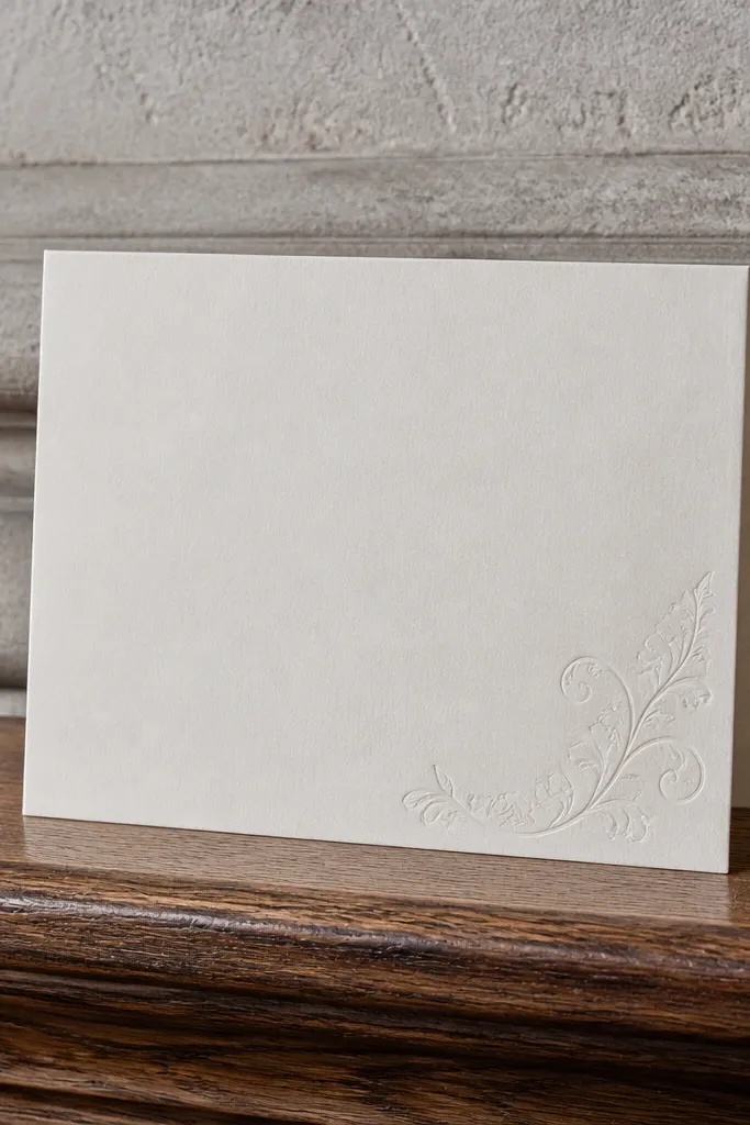 Cream card with white text and a subtle embossed corner motif
